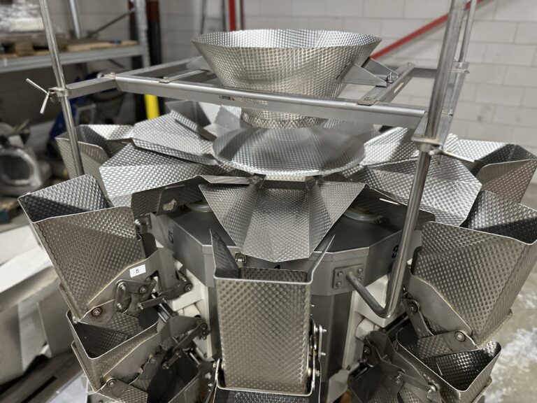 The infeed hopper with the dispersion plate on top of the weigher